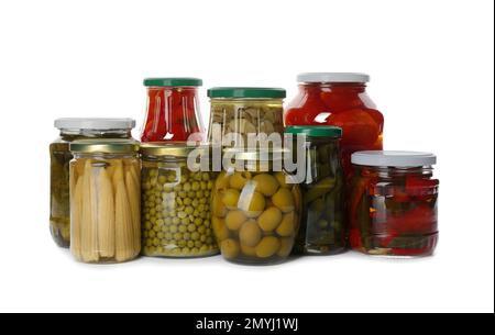 Pots en verre avec différents légumes marinés et champignons sur fond blanc Banque D'Images