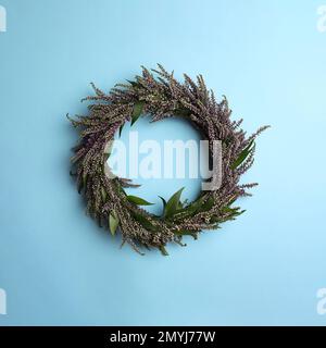 Belle couronne de bruyère sur fond bleu clair, vue de dessus. Fleurs automnales Banque D'Images