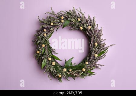 Belle couronne de bruyère sur fond violet, vue de dessus. Fleurs automnales Banque D'Images