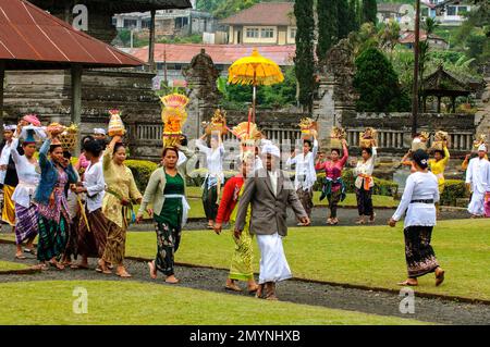 Procession de fidèles hindous marchant avec des offrandes au temple, complexe bouddhiste hindou du temple Pura Ulun Danu Bratan, Candi Kuning, Lac Bratan, Bali Banque D'Images