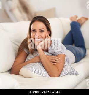 Être heureux à la maison est le but ultime de toute ambition. une belle femme assise à l'intérieur. Banque D'Images