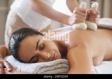Utilisation des propriétés de guérison de la chaleur. un agréable profiter d'un massage avec des compresses chaudes. Banque D'Images