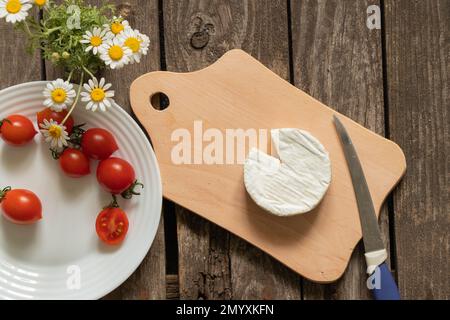 fromage brie doux et tomates cerises sur une table Banque D'Images