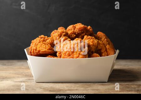 De savoureux morceaux de poulet frits sur une table en bois Banque D'Images