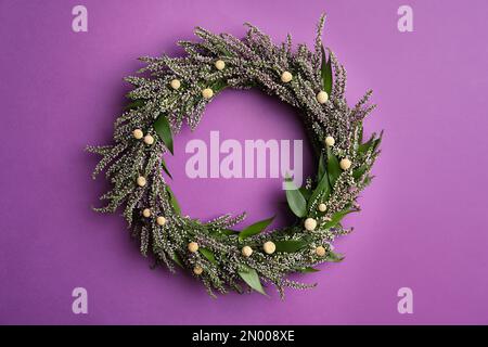 Belle couronne de bruyère sur fond violet, vue de dessus. Fleurs automnales Banque D'Images