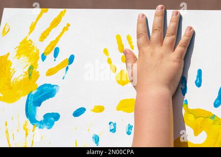 impressions lumineuses des mains des enfants à partir de la peinture sur le mur, de l'arrière-plan, de la texture, du format horizontal. Banque D'Images