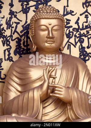 Paix Stupa, Pokhara, Népal. Bouddha d'or formant mudra avec les deux mains. Banque D'Images