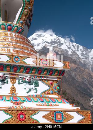 Chhomrong, Népal. Enveloppé dans la statue en plastique de Bouddha sur le point d'être situé dans le nouveau village stupa. Annapurna Sud en arrière-plan. Banque D'Images