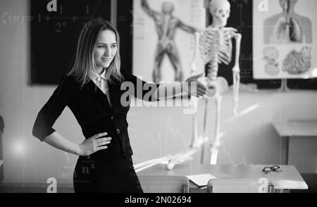 Jeune fille à l'école primaire de l'enseignant dans la classe in front of blackboard Banque D'Images