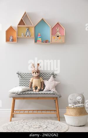 Étagères et banc en forme de maison avec jouets dans la chambre des enfants. Design intérieur Banque D'Images