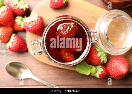Délicieux confiture de fraises marinées et baies fraîches sur table en bois, plat Banque D'Images