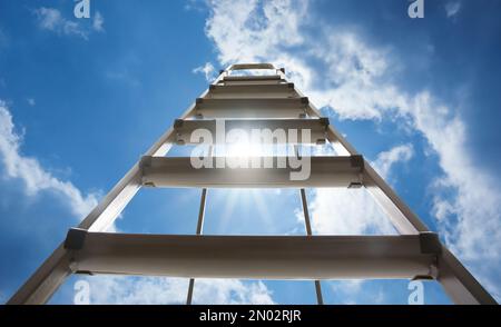 Escabeau en métal contre ciel bleu avec nuages, vue en angle bas Banque D'Images