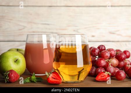 Verres de jus délicieux et fruits frais sur une table en bois Banque D'Images