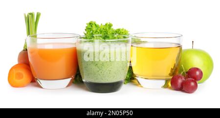 Verres de jus délicieux, fruits frais et légumes sur fond blanc Banque D'Images