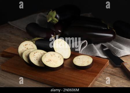 Couper et tout les aubergines mûres crues sur une table en bois Banque D'Images