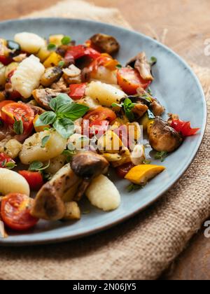 Gnocchi aux légumes d'été sautés et aux champignons. Banque D'Images