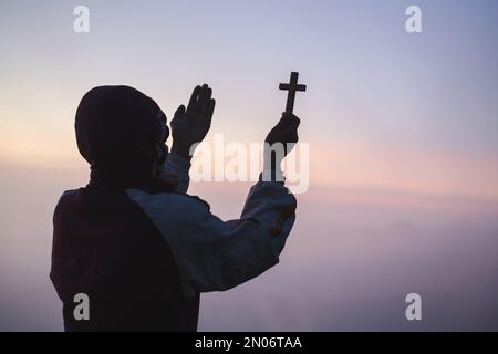 La main humaine tient la croix et la paume ouverte de culte. Eucharistie la thérapie bénir Dieu aidant à se repentir Catholique Pâques Carême prier. Christian concept backgrou Banque D'Images