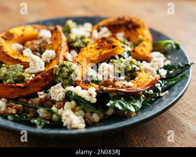 Courge rôtie sur le couscous et les lentilles avec le Kale et le feta vegan maison Banque D'Images