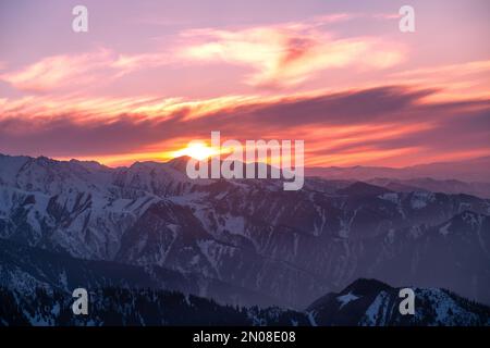 Vue imprenable sur la montagne dans les derniers rayons du soleil couchant ; chaîne de montagnes enneigée au coucher du soleil Banque D'Images