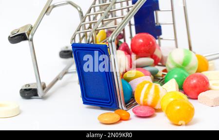 il y a beaucoup de bonbons aux saveurs variées et colorés dans un petit panier. Banque D'Images