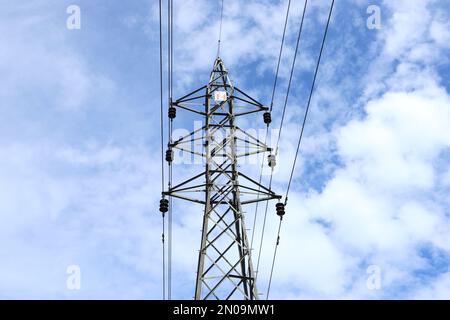 Vue à angle bas d'une tour électrique haute tension sous le ciel bleu Banque D'Images