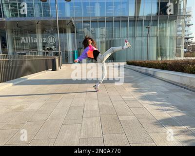 Une image fantastique d'une jeune fille, dansant dans des vêtements à la mode, sous la tour CityLife Allianz, la tour Isozaki, CityLife, Milan, Italie Banque D'Images