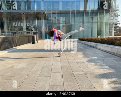 Une image fantastique d'une jeune fille, dansant dans des vêtements à la mode, sous la tour CityLife Allianz, la tour Isozaki, CityLife, Milan, Italie Banque D'Images