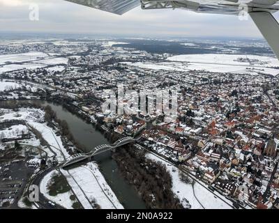 Vue aérienne du Neckar et du pont à Seckenheim (Mannheim) pendant l'hiver couvert de neige. Avion léger survolant la ville après le départ Banque D'Images