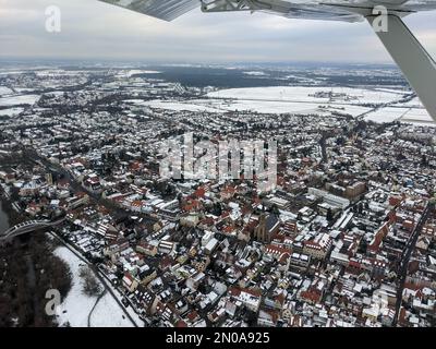 Vue aérienne de la ville de Seckenheim dans la ville de Mannheim pendant l'hiver couverte de neige. Avion léger survolant la ville après le départ de l'aéroport régional Banque D'Images