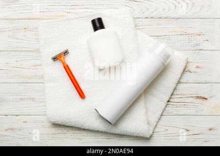 kit homme à raser. machine à raser, serviette, lotion et mousse à raser sur fond coloré. Articles de bain pour hommes vue du dessus. Banque D'Images