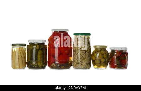 Pots en verre avec différents légumes marinés et champignons sur fond blanc Banque D'Images