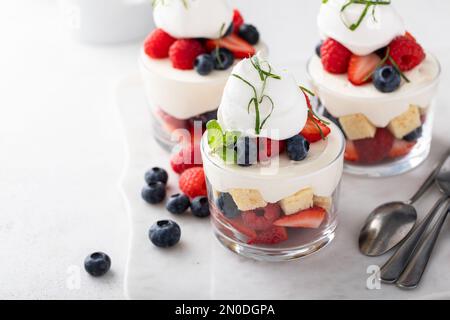 Gâteau aux petits fruits ou parfait avec mousse au fromage à la crème et crème fouettée, dessert dans une idée de verre Banque D'Images