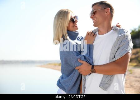 Couple heureux en pulls élégants sur la plage Banque D'Images