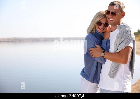 Couple heureux en pulls élégants sur la plage Banque D'Images