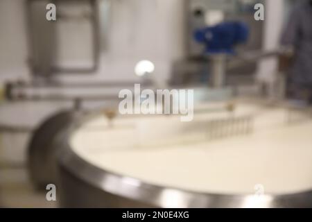 Vue floue du réservoir de préparation de caillé avec du lait à l'usine de fromage Banque D'Images