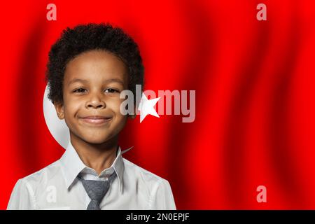 Enfant turc sur fond de drapeau de Turquie. Concept d'éducation et d'enfance Banque D'Images