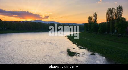 magnifique lever de soleil sur le front de mer de la rivière uzh. beau paysage urbain du centre-ville d'uzhhorod au printemps. remblai herbeux de la plus longue allée de linden dedans Banque D'Images