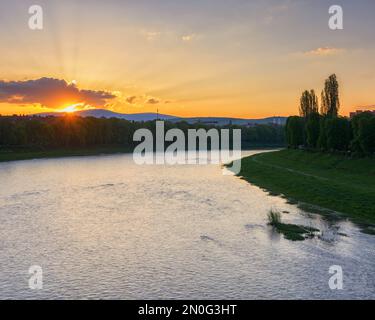 magnifique lever de soleil sur le front de mer de la rivière uzh. beau paysage urbain du centre-ville d'uzhhorod au printemps. remblai herbeux de la plus longue allée de linden dedans Banque D'Images