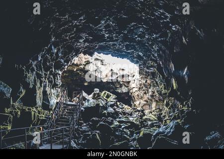 Grotte avec ouverture et lumière à travers. Marche à travers la grotte de lave en Islande Banque D'Images