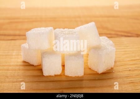 Plusieurs cubes de sucre blanc, gros plan, sur une table en bois. Banque D'Images