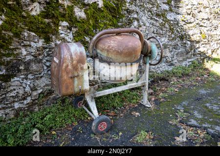 Ancien mélangeur de béton utilisé pour le travail de maçonnerie maintenant rouillé par le temps Banque D'Images