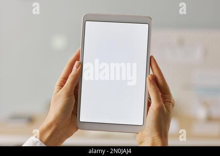 Gros plan minimaliste des mains des femmes tenant une tablette numérique avec maquette d'écran blanc Banque D'Images