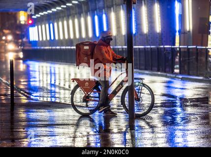 Rue à la gare principale, Lieferando Courier, cycliste, temps pluvieux, centre ville, Dans la soirée, Essen, NRW, Allemagne, Banque D'Images