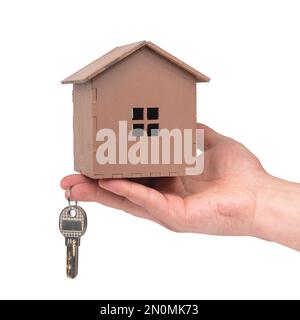 Clés à main et maison en bois isolée sur fond blanc Banque D'Images