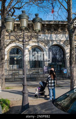 Parents avec voiture-bébé en face de l'Hôtel-Dieu situé sur l'Île de la Cité dans le 4th arrondissement de Paris, fondé par Saint Landry. Banque D'Images