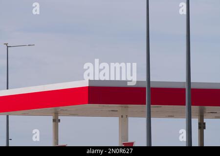 Station-service affichant une structure abstraite de bâtiment avec des couleurs rouges et fond gris ciel, Victoria Australie. Banque D'Images