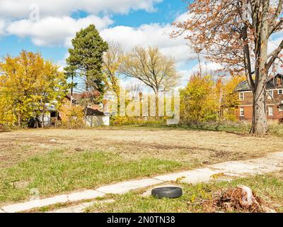 Un pneu près du trottoir se trouve devant un terrain vide dans la région de Highland Park, à Detroit. Banque D'Images
