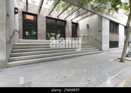 Grand portail d'accès à une maison résidentielle avec des escaliers en granit et des portes en métal noir et en verre Banque D'Images