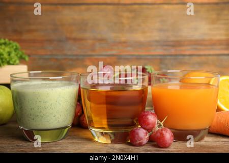 Verres de jus délicieux et fruits frais sur une table en bois Banque D'Images