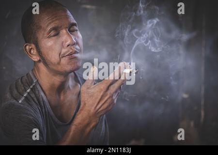 homme fumant une cigarette. Propagation de la fumée de cigarette. Concept de renoncement au tabac Banque D'Images